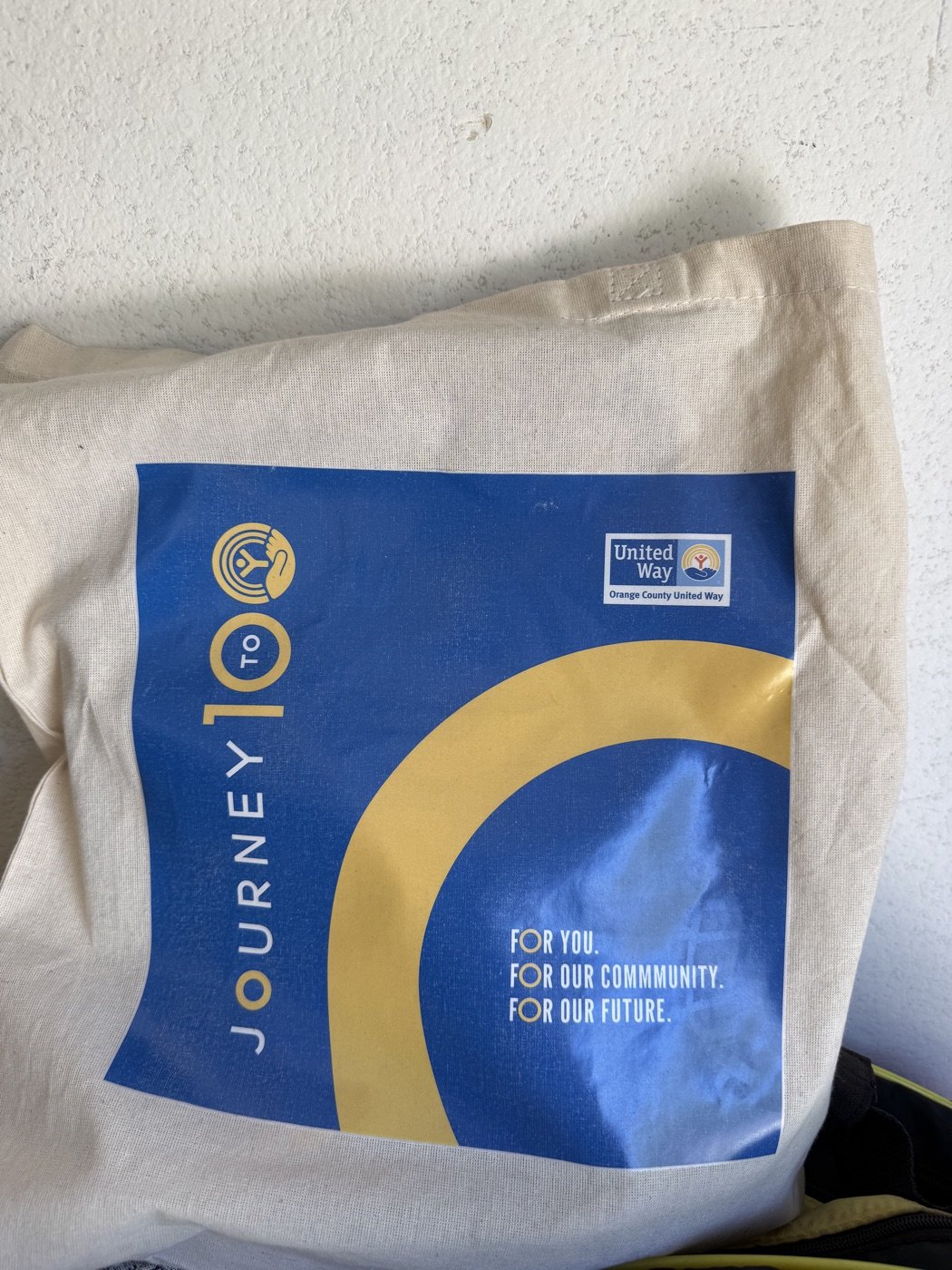 Orange County United Way tote bag printed with their 'Journey to 100' campaign branding