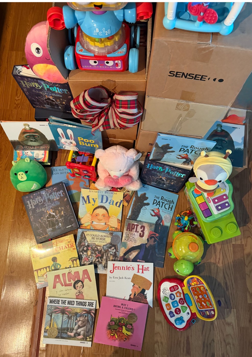 More donated books, including Harry Potter box sets and picture books, plus educational toys, boxed up and ready for the next delivery